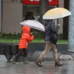 personas caminando bajo la lluvia en Santiago de Chile