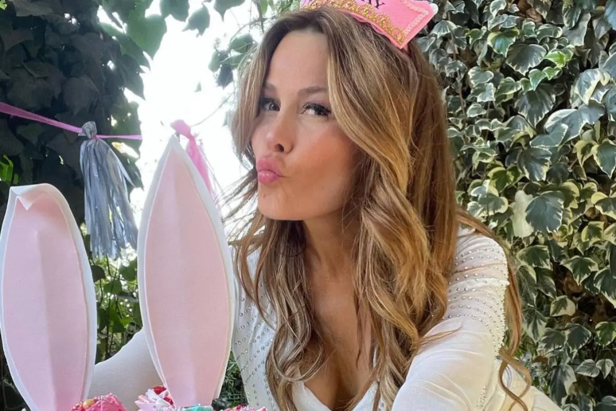 Cathy Barriga soplando una torta de cumpleaños.